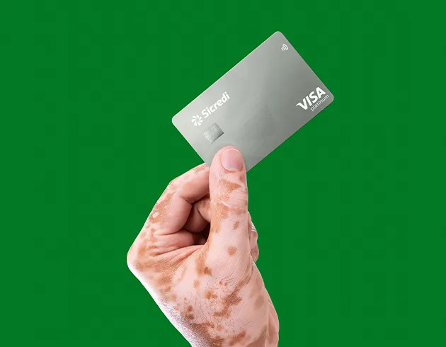  Imagem segurando um cartão de crédito cinza com um fundo verde 