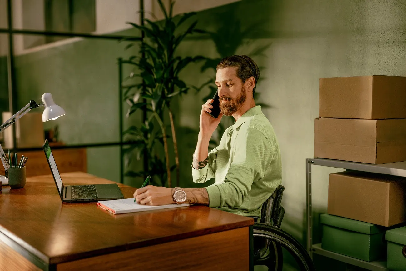  Homem cadeirante no celular trabalhando 