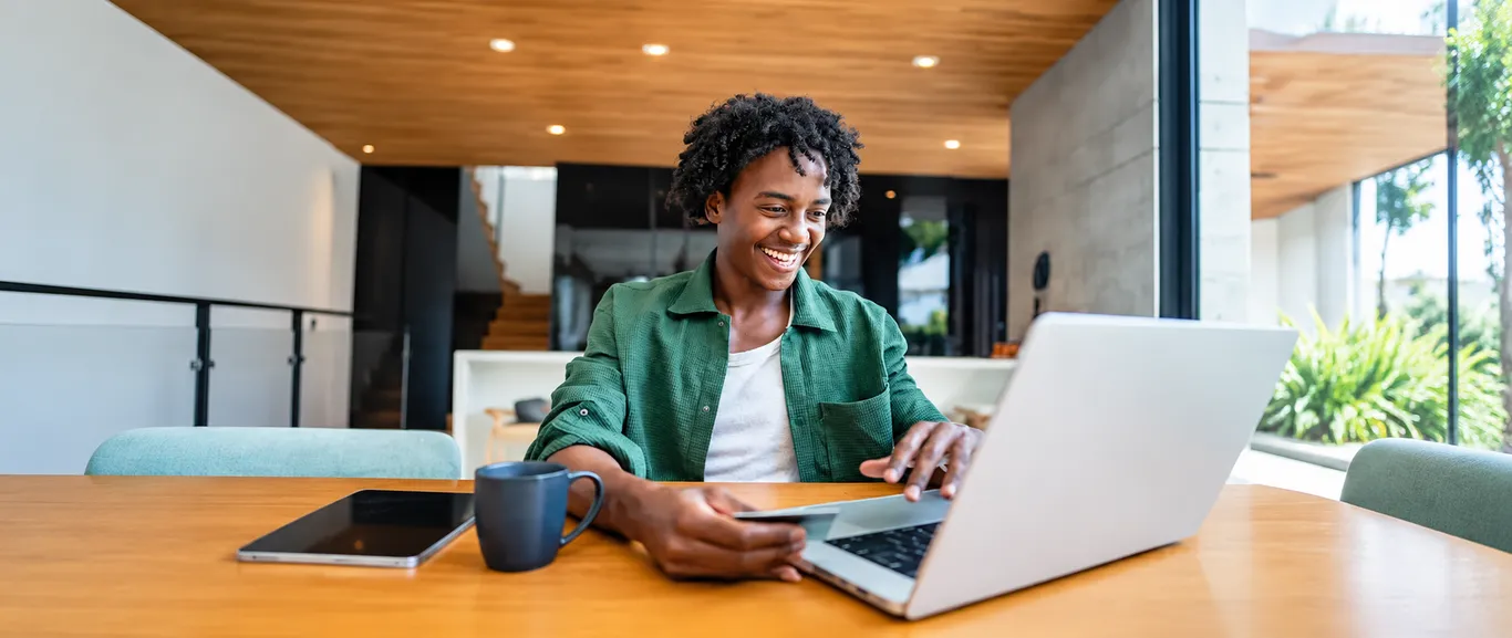  homem negro sorrindo na frente do computador 