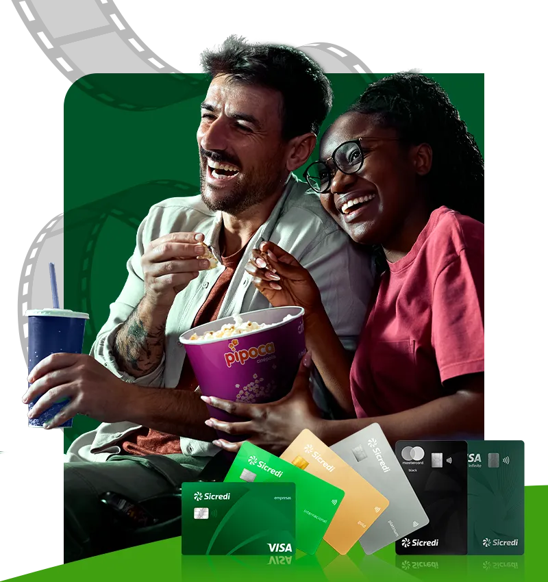  Banner promocional da Sicredi com benefício de cinema. Em destaque, duas pessoas sentadas compartilhando um balde de pipoca e um refrigerante. Na parte inferior da imagem, aparecem cartões Sicredi Visa e Mastercard de diferentes categorias. 