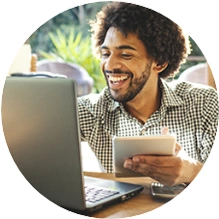  homem sorrindo e usando um tablet e um computador 