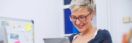  mulher loira de cabelo curto e óculos lendo no tablet 